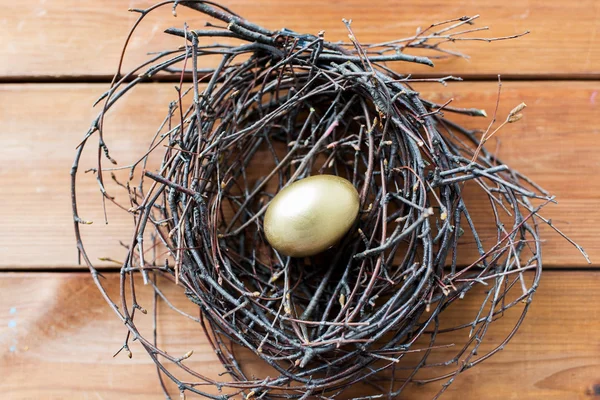 Altın Paskalya yumurta yuvada ahşap üzerine yakın çekim — Stok fotoğraf