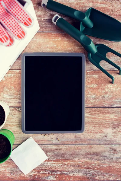 Close up of tablet pc and garden tools on table — Stock Photo, Image