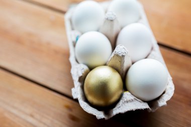 close up of white and gold eggs in egg box clipart