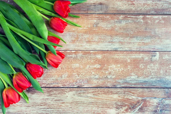 Nahaufnahme roter Tulpen auf hölzernem Hintergrund — Stockfoto