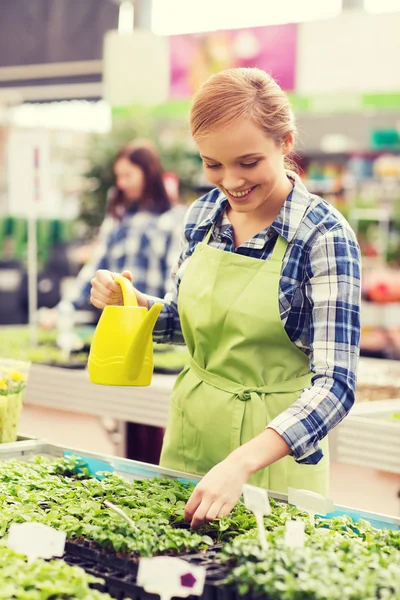 Gelukkige vrouw met gieter in kas — Stockfoto