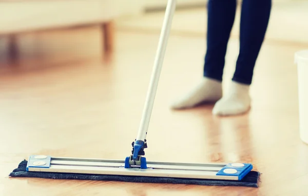 Primer plano de la mujer con piso de limpieza de la fregona en casa —  Fotos de Stock