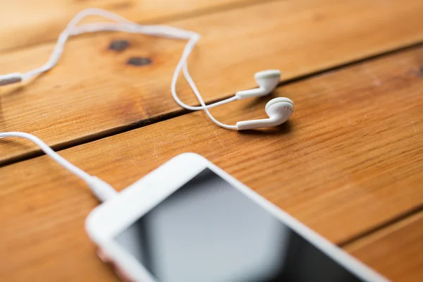 Primer plano de teléfonos inteligentes y auriculares en madera —  Fotos de Stock