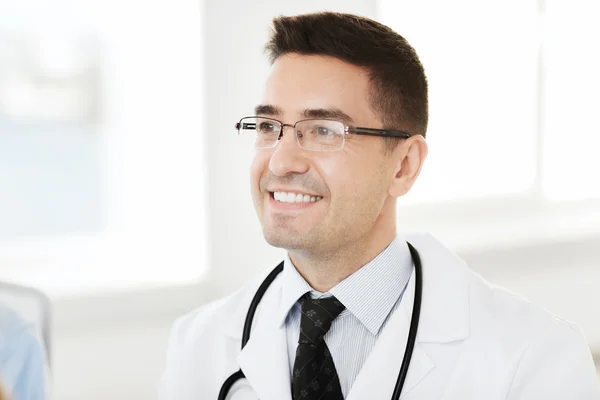 Médico varón sonriente en bata blanca y gafas graduadas — Foto de Stock