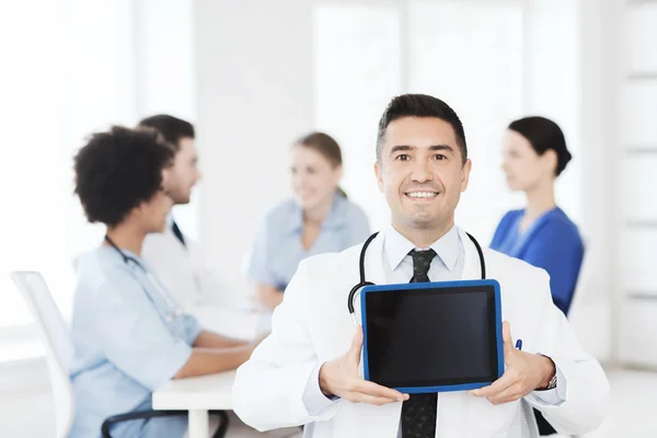 Zufriedener Arzt mit Tablet-PC über Team in Klinik — Stockfoto