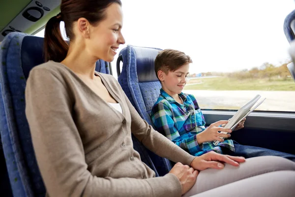 Happy family with tablet pc sitting in travel bus — Stock Photo, Image