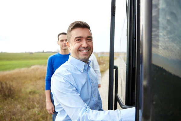 Group of happy male passengers boarding travel bus — Stock Photo, Image