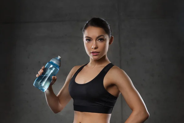 Жінка п'є воду з пляшки в спортзалі — стокове фото