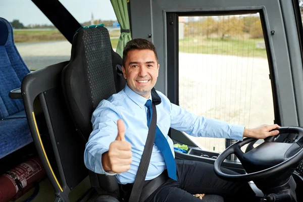 Conductor feliz conduciendo autobús y nevando pulgares hacia arriba —  Fotos de Stock