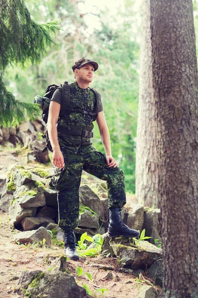 Jovem soldado com mochila na floresta — Fotografia de Stock