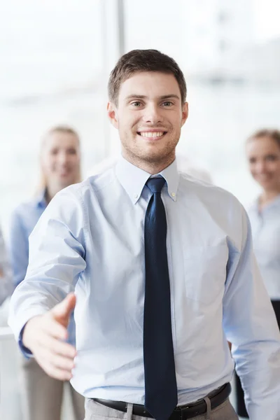 Sorridente empresário fazendo aperto de mão no escritório — Fotografia de Stock