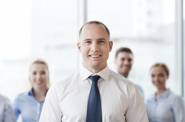 Biznesmen uśmiechający się z kolegami z biura — Zdjęcie stockowe