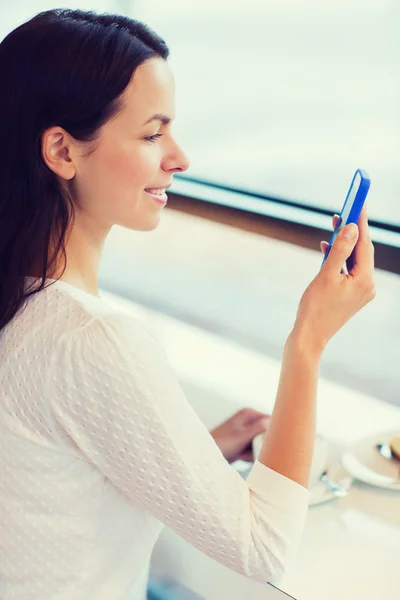 Lächelnde Frau mit Smartphone und Kaffee im Café — Stockfoto