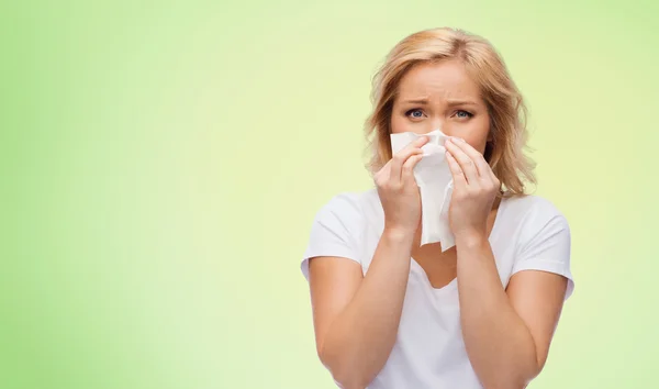 Mujer infeliz con servilleta de papel soplando la nariz — Foto de Stock