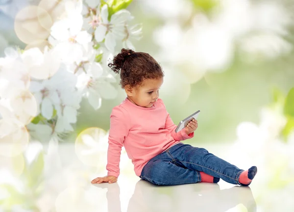 Sorrindo pequena menina brincando com smartphone — Fotografia de Stock