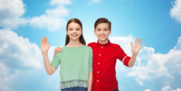 Happy boy and girl waving hand — Stock Photo, Image