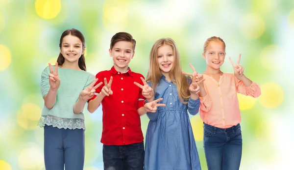 Niño feliz y las niñas mostrando la paz signo de mano —  Fotos de Stock