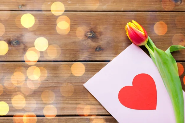Закрыть цветы и поздравительную открытку с сердцем — стоковое фото