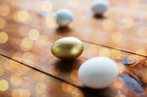 Primer plano de huevos de Pascua dorados y blancos en madera —  Fotos de Stock