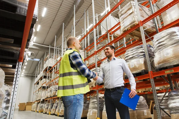Worker and businessmen with clipboard at warehouse — Stock Photo, Image