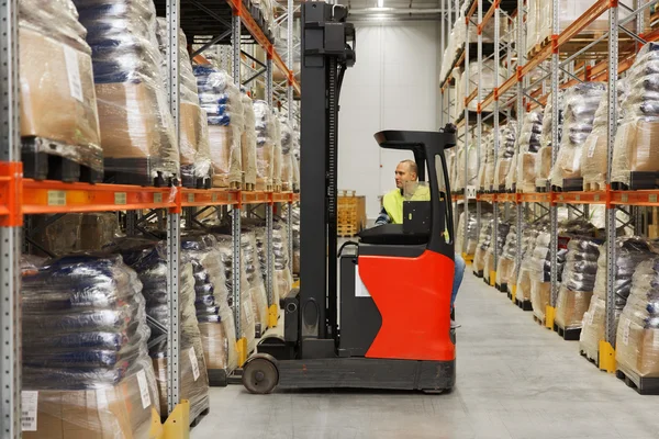 Man on forklift loading cargo at warehouse — Stock Photo, Image