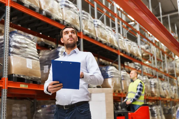 Businessman with clipboard at warehouse — Stock Photo, Image