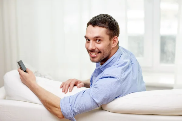 Gelukkig man met smartphone thuis — Stockfoto