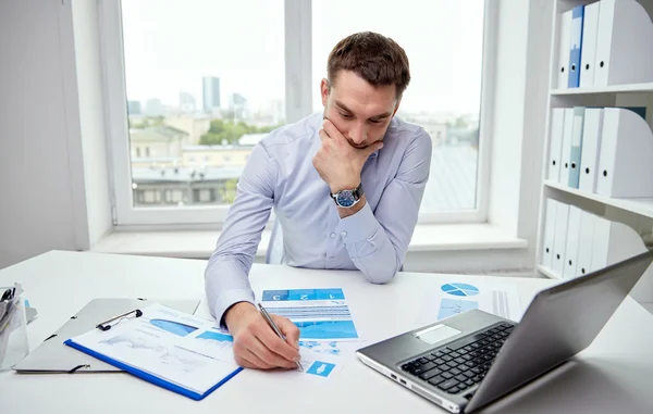 Stressed businessman with papers in office — Stock Photo, Image