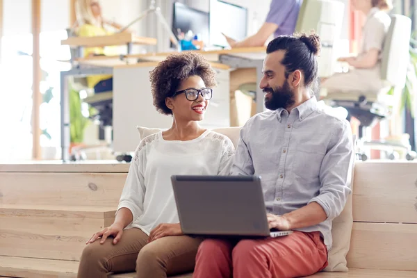 Équipe créative heureuse avec ordinateur portable au bureau — Photo