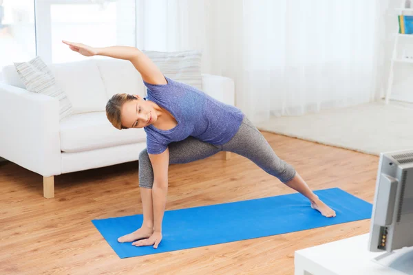 Frau macht Yoga-Dreieck auf Matte — Stockfoto