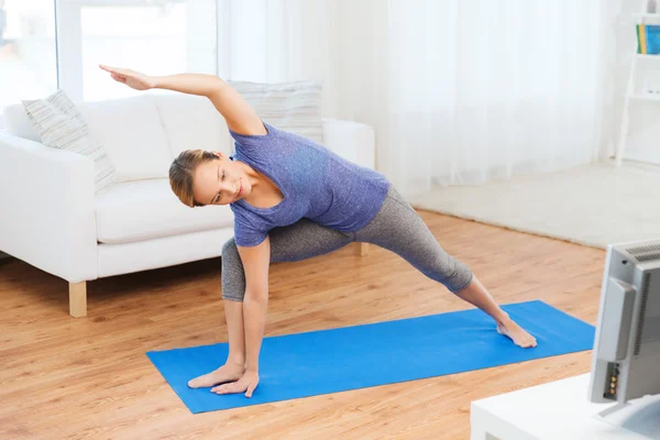 Mulher fazendo ioga bikram triângulo pose no tapete — Fotografia de Stock