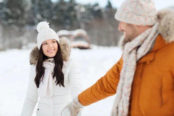 Gelukkige paar wandelen langs besneeuwde winter veld — Stockfoto