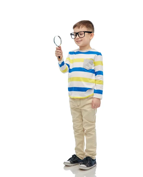 Little boy in eyeglasses with magnifying glass — Stock Photo, Image