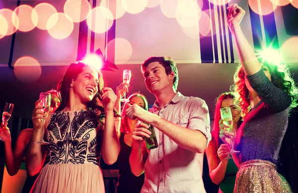 Lachende vrienden met wijn glazen en bier in club — Stockfoto