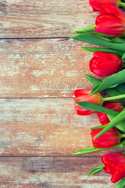 Gros plan de tulipes rouges sur fond en bois — Photo