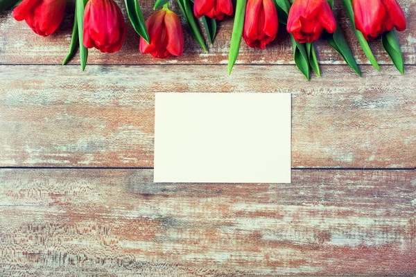 Czerwone tulipany i czystym papierze lub list z bliska — Zdjęcie stockowe