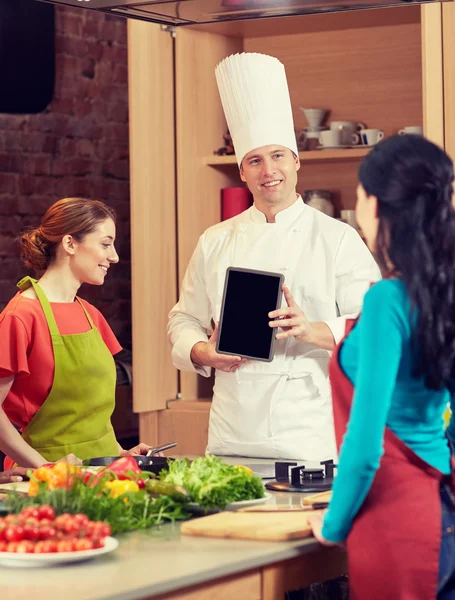 Gelukkig vrouwen met chef-kok en tablet pc in keuken — Stockfoto