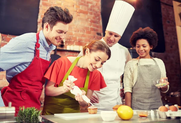 Amigos felizes e cozinheiro chef assar na cozinha — Fotografia de Stock