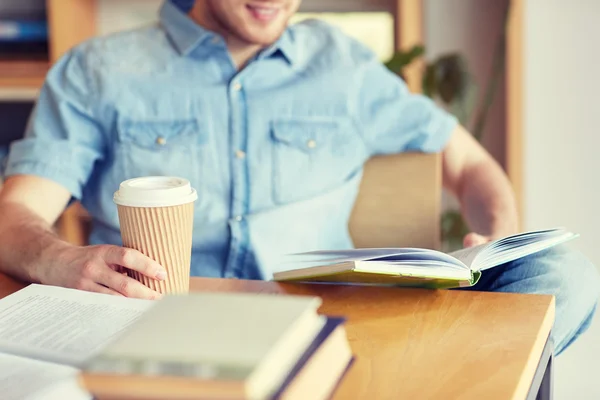 Glückliche Studentin liest Buch und trinkt Kaffee — Stockfoto