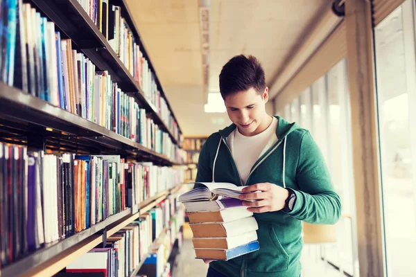 Estudiante feliz o hombre con libro en la biblioteca —  Fotos de Stock