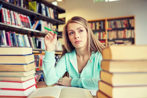 Estudiante aburrido o mujer joven con libros en la biblioteca — Foto de Stock