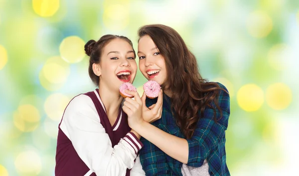 Счастливые симпатичные девочки-подростки едят пончики — стоковое фото