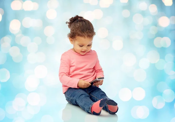 Sorrindo pequena menina brincando com smartphone — Fotografia de Stock