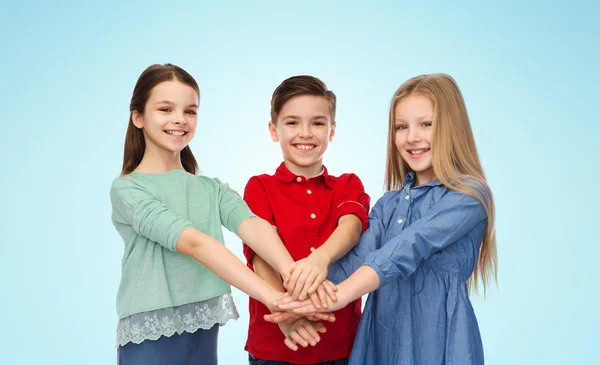 Niño feliz y las niñas con las manos en la parte superior — Foto de Stock