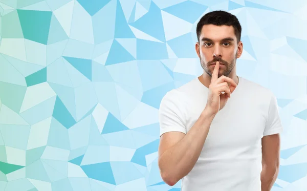 Man making hush sign over low poly background — Stockfoto