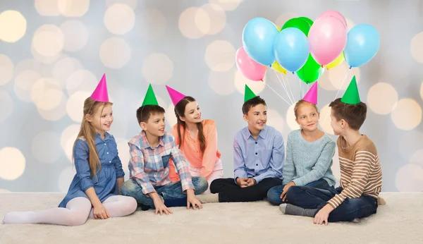 Щасливі усміхнені діти у вечірніх капелюхах на день народження — стокове фото