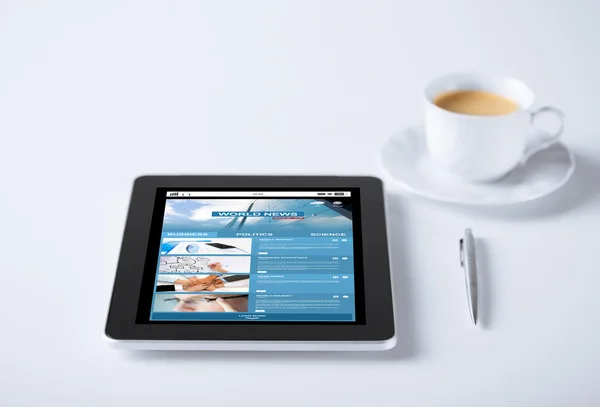 Tablet pc with world news web page and coffee — Stock Fotó