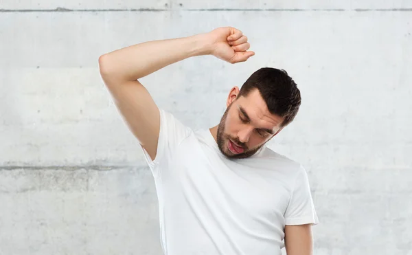 Jeune faisant geste de potence sur le mur gris — Photo