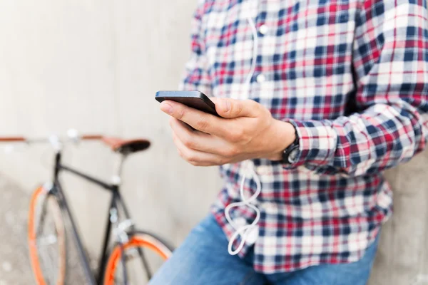 Close up of hipster man with smartphone and bike — Stock Photo, Image