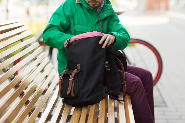 Close up of man with backpack on city bench — Zdjęcie stockowe